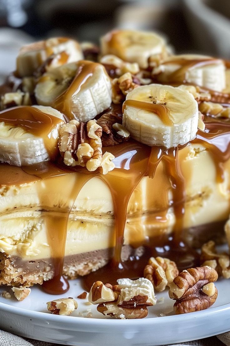 a white plate topped with banana slices and caramel drizzled on top of it