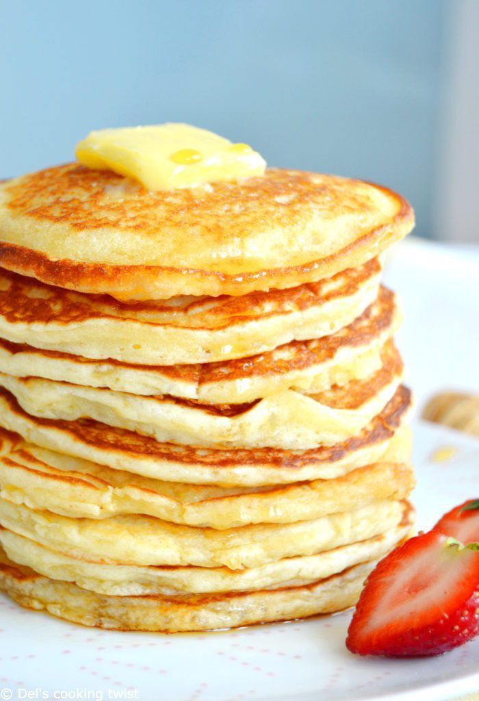 a stack of pancakes with butter and strawberries