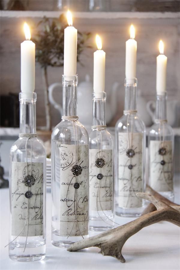 several bottles with candles in them sitting on a table next to antlers and antlers