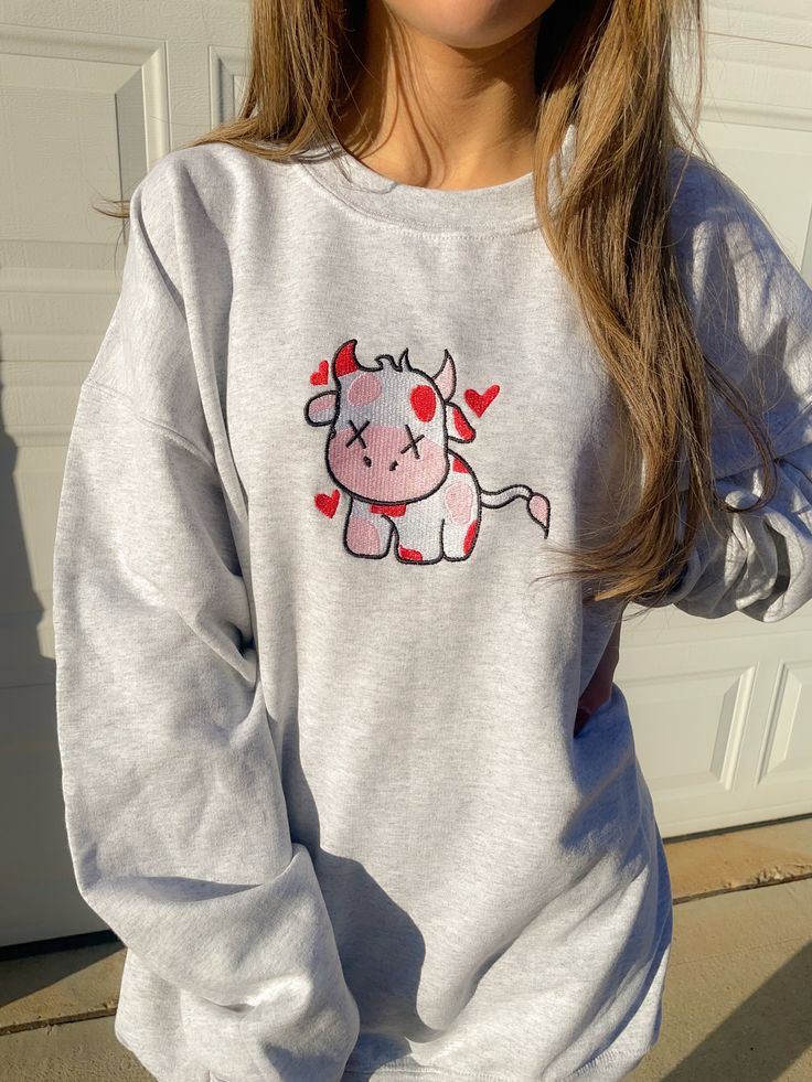 Look sweet and comfy in our Valentine Cow Crewneck Sweatshirt. This sweatshirt features long sleeves, a crew neckline, and beautiful front embroidery. The Unisex Sizing makes the sweatshirt run slightly larger than your average sweatshirt for women. Most men find their normal size to be more snug. If you want a slightly looser fit, size up one size. Please check out our size chart for measurements to ensure an accurate fit. PLEASE BE SURE TO INPUT YOUR CORRECT SIZE/COLOR + SHIPPING ADDRESS. We w Oversized Embroidered Sweatshirt For Loungewear, Cozy Fit Crew Neck Sweatshirt For Fall, Cotton Crew Neck Sweatshirt With Embroidered Graphics, Crew Neck Sweats With Letter Print For Spring, Spring Graphic Print Crew Neck Sweats, Cozy Fleece Crew Neck Sweatshirt, Trendy Crew Neck Hoodie With Cozy Fit, Cute Gray Sweatshirt For Winter, Cozy Fit Fleece Sweatshirt Crew Neck