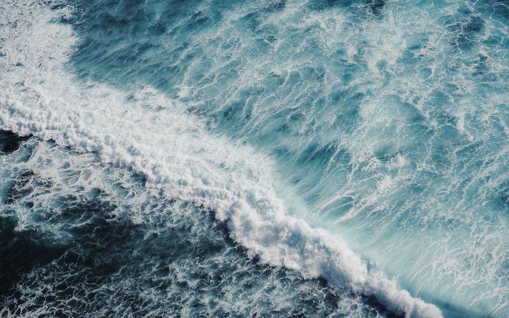 an aerial view of the ocean with waves