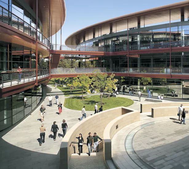 an aerial view of people walking around in front of a building