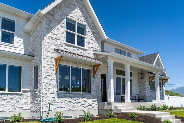 a white house with lots of windows and landscaping