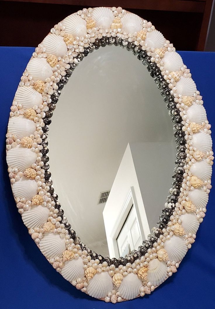 there is a mirror with seashells on it and a building in the background