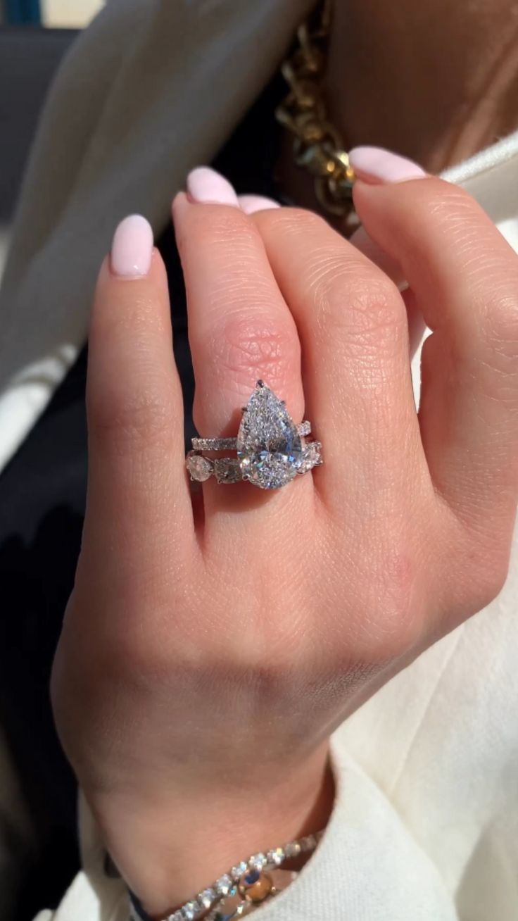 a woman's hand with a diamond ring on it