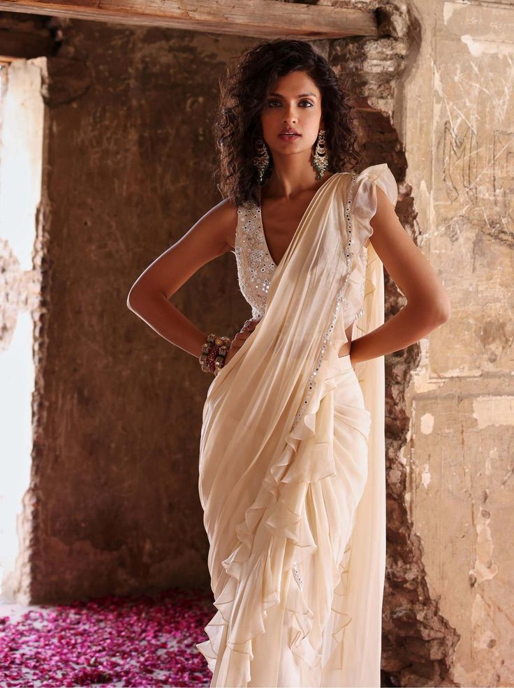 Discover elegance redefined with this embellished choli paired seamlessly with a pre-stitched ruffle sari boasting an adorned pallu. This ensemble effortlessly combines traditional charm with contemporary flair, making it a captivating choice for any special occasion. Flaunt your style effortlessly and make heads turn with this exquisite ensemble. Traditional Pre-draped Saree With Ruffles, Ruffled Pre-draped Saree For Diwali, Designer Pre-draped Saree With Ruffles, Festive Draped Choli With Ruffles, Bollywood Style Pre-draped Saree With Ruffles, Festive Draped Ruffle Choli, Festive Draped Ruffled Choli, Festive Draped Ruffles Choli, Elegant Draped Choli With Ruffles