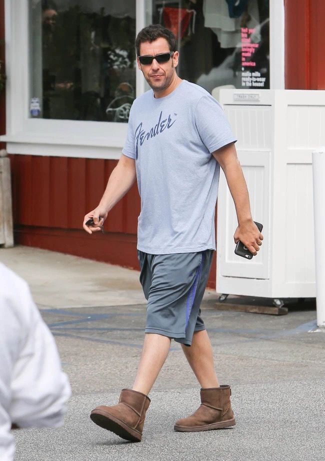 a man walking down the street in shorts and a t - shirt