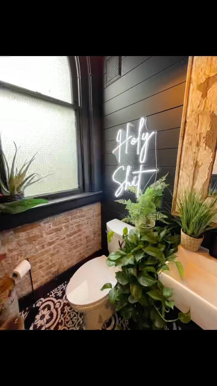 a bathroom with graffiti on the wall next to a toilet and plants in a pot