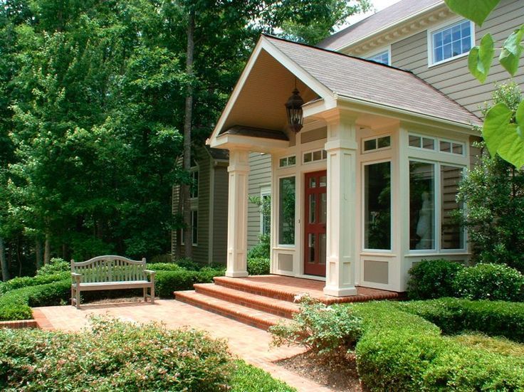 a house with steps leading up to it and a bench in the front yard area