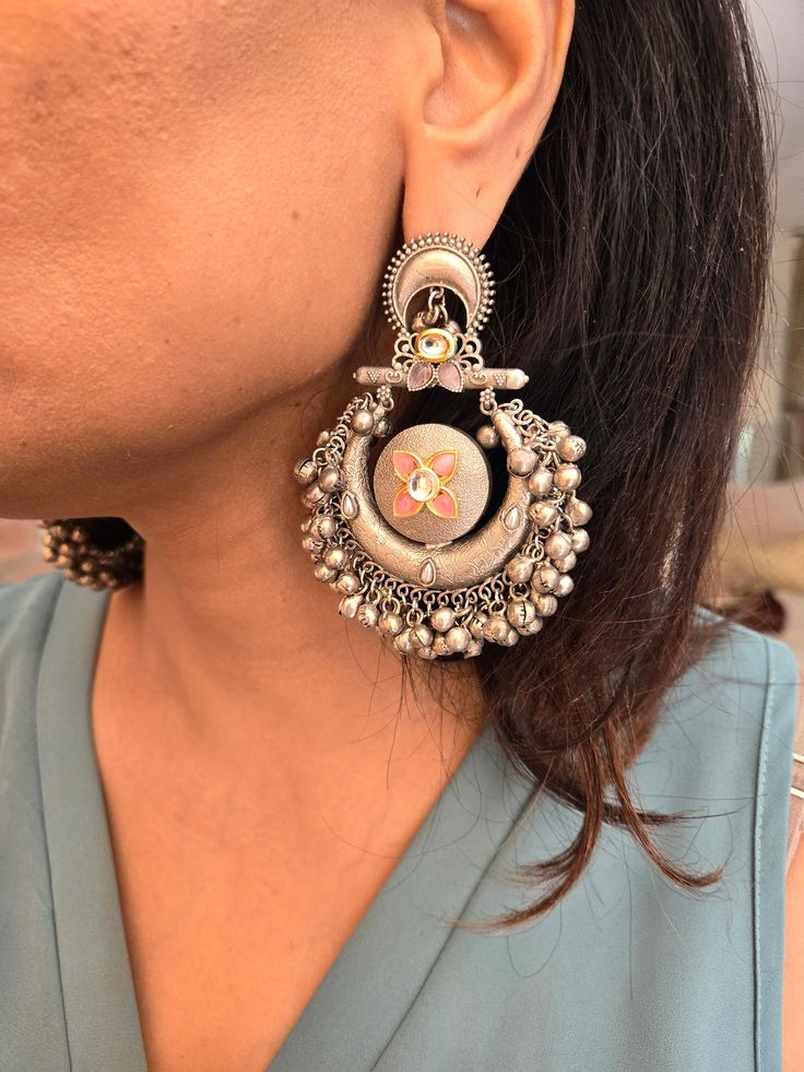 Statement silver boho ghungroo Kundan chandbaali earrings for a stunning look. Perfect for adding a unique and stylish touch to any outfit. Earring Dimensions:  Approximately 3.2 Inches Long  Approximately 2 Inches Wide  A Earring Weight is 1.3 oz All our products are crafted using traditional skills from our rich heritage. The manual nature of these crafts means that irregularities or variations are inherent in the handcrafting process. Festive Silver Chandelier Earrings With Tilla, Silver Kundan Chandelier Dangle Earrings, Silver Kundan Fusion Danglers, Silver Metal Chandbalis For Festive Occasions, Heavy Silver Fusion Danglers, Silver Chandbali Fusion Earrings, Silver Kundan Danglers For Festivals, Fusion Style Silver Chandbalis With Latkans, Silver Fusion Chandbalis With Latkans