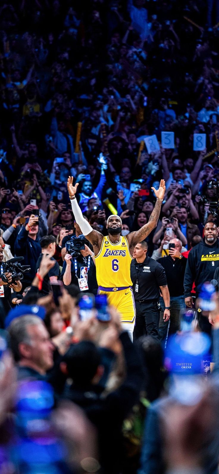 a man in a yellow jersey is holding his arms up as he walks through the crowd