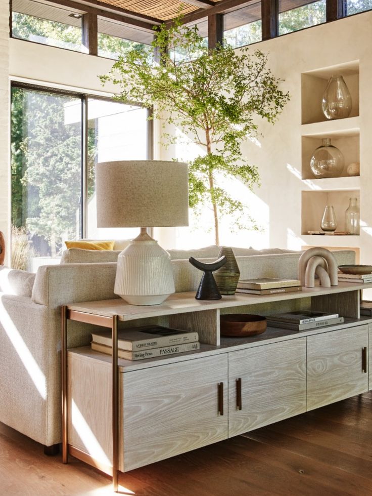 a living room filled with furniture and a tree in the middle of it's centerpiece