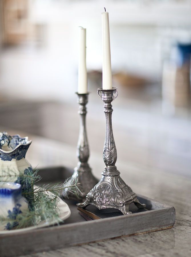 two silver candlesticks sitting on top of a tray