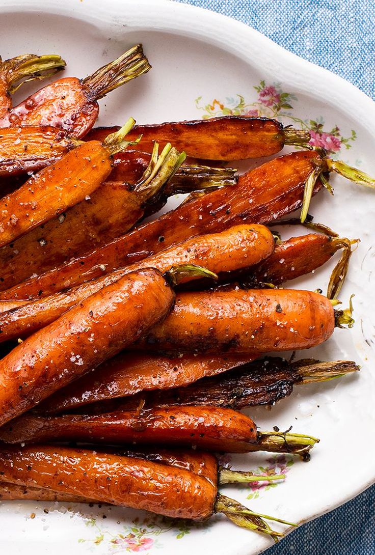 roasted carrots on a white plate with sprinkles