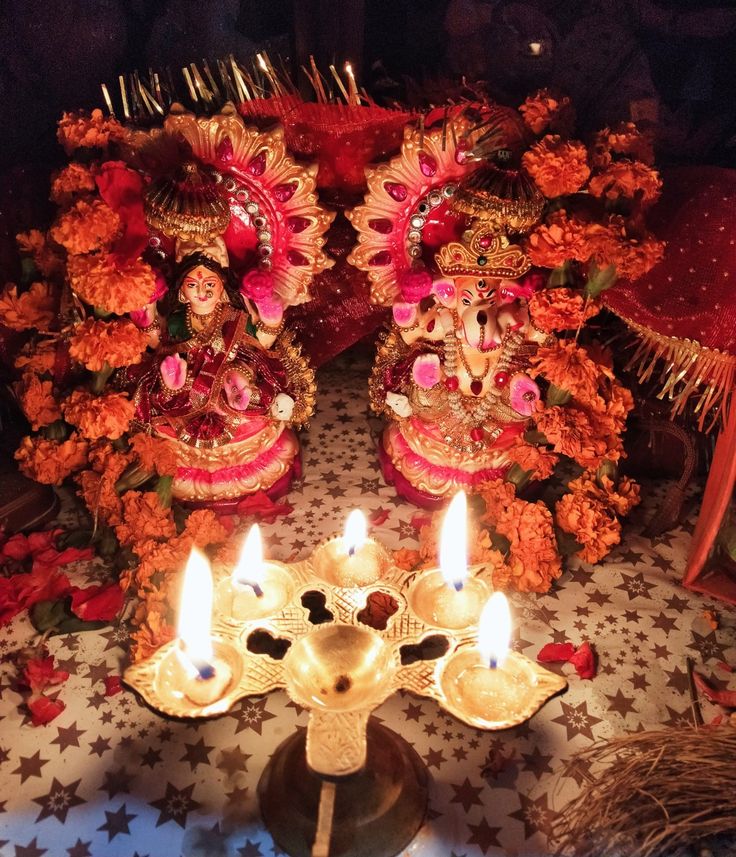 there are two candles on the table with decorations in front of them and one candle is lit