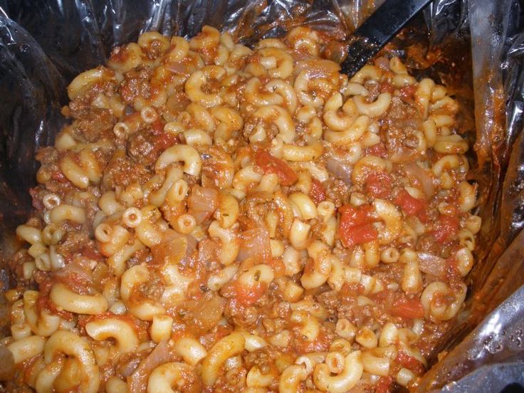 the pasta dish is prepared and ready to be cooked in the oven, with tongs