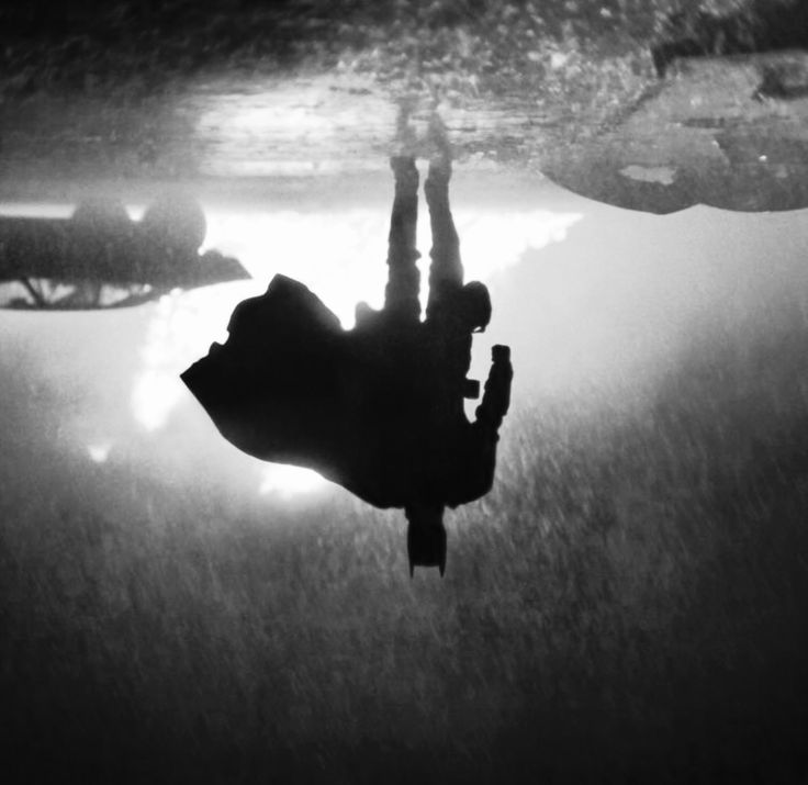 an underwater view of two people diving in the water with their feet on the ground