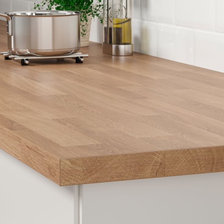 a wooden counter top in a kitchen next to a pot and pan on the counter