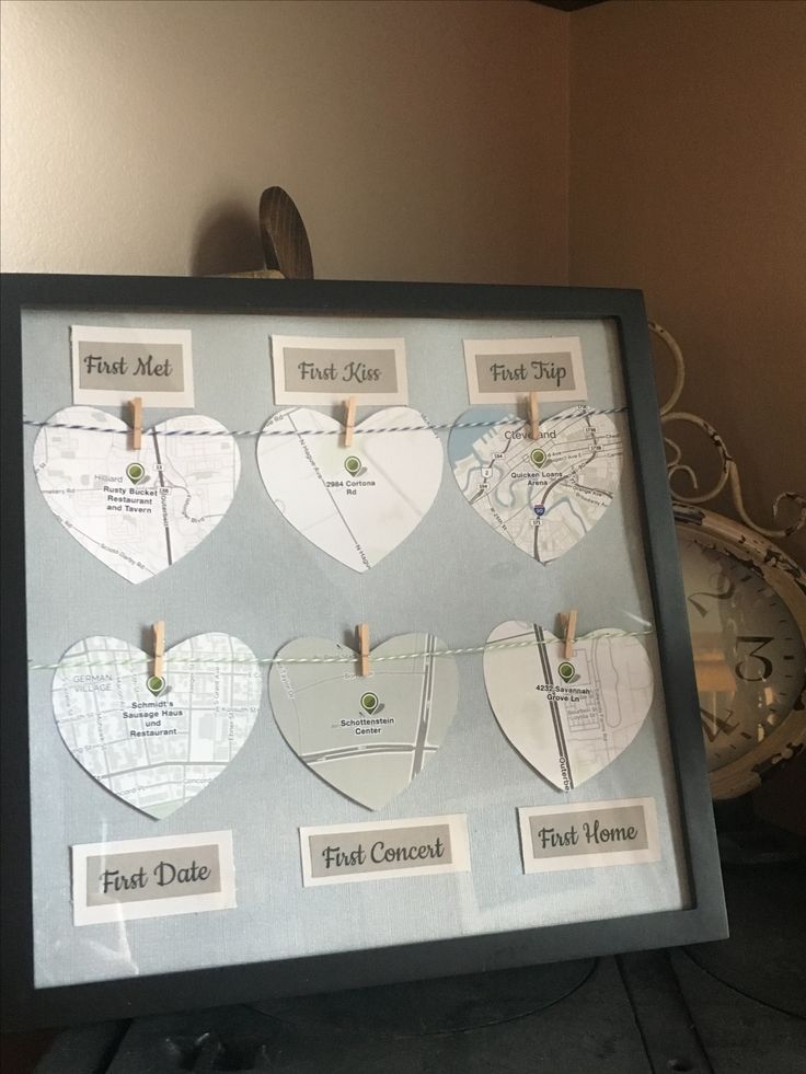 there are many heart shaped pictures hanging on the clothes pegs in this shadow box