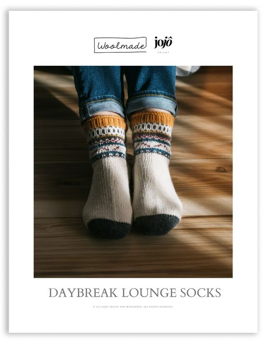 a person wearing socks that are knitted in different colors and patterns with the words, daybreak lounge socks