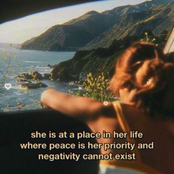 a woman sitting in the back seat of a car looking out at mountains and water