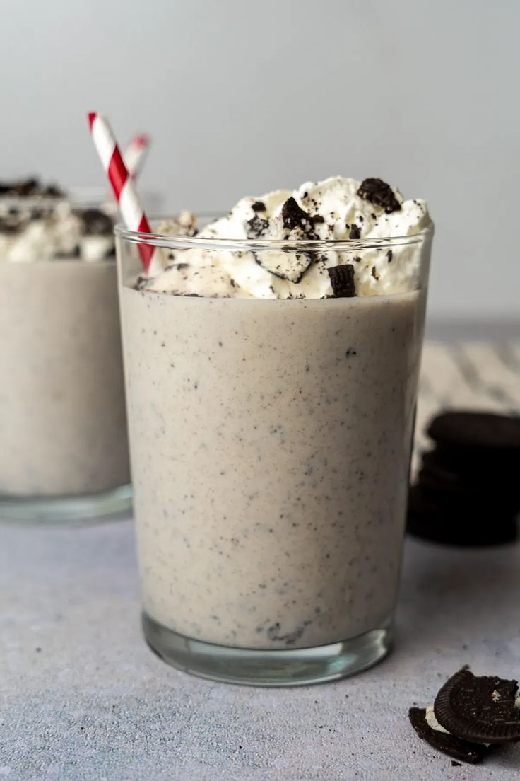 two glasses filled with ice cream and oreo cookies next to each other on a table