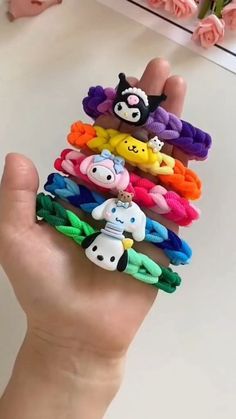 a hand holding a bunch of different colored hair ties