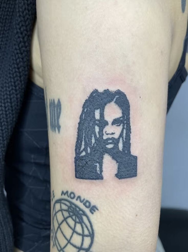 a woman's arm with a tattoo of a bob marley on the left side