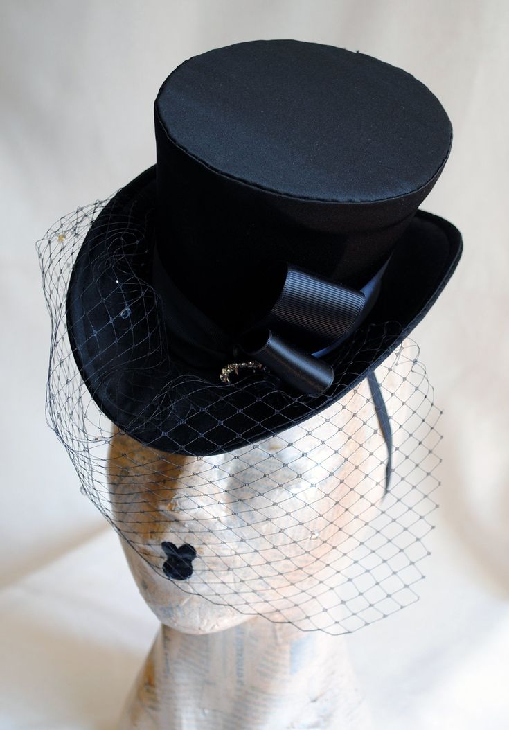 This burlesque style mini top hat is covered with fine black satin. It is embellished with black ribbon and a beautiful black and clear crystal button. The piece is completed with gorgeous black birdcage veil with clear sparkling rhinestones. Measurements : height 4 inches( 10 cm ) front to back 9 inches ( 22 cm ) side to side 7.5 inches ( 19 cm ) This mini top hat is fully lined with satin and attaches to the head with thin elastic that goes under the hair, to ensure stability and achieve that Black Birdcage Veils, Veil Black, Elizabethan Collar, Ladies Hat, Mini Top Hat, Birdcage Veil, Cocktail Hat, Crystal Buttons, Mini Top