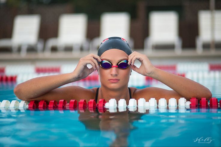 a woman in a swimming pool with her hands on her head and sunglasses over her eyes