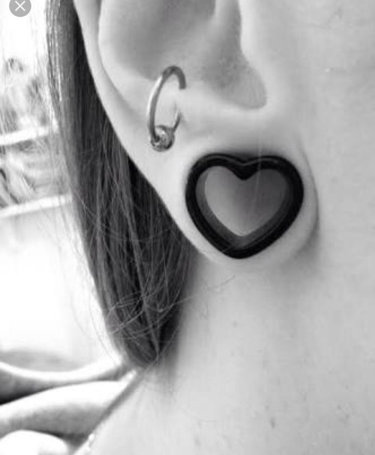 a close up of a person's ear with a heart shaped object attached to it