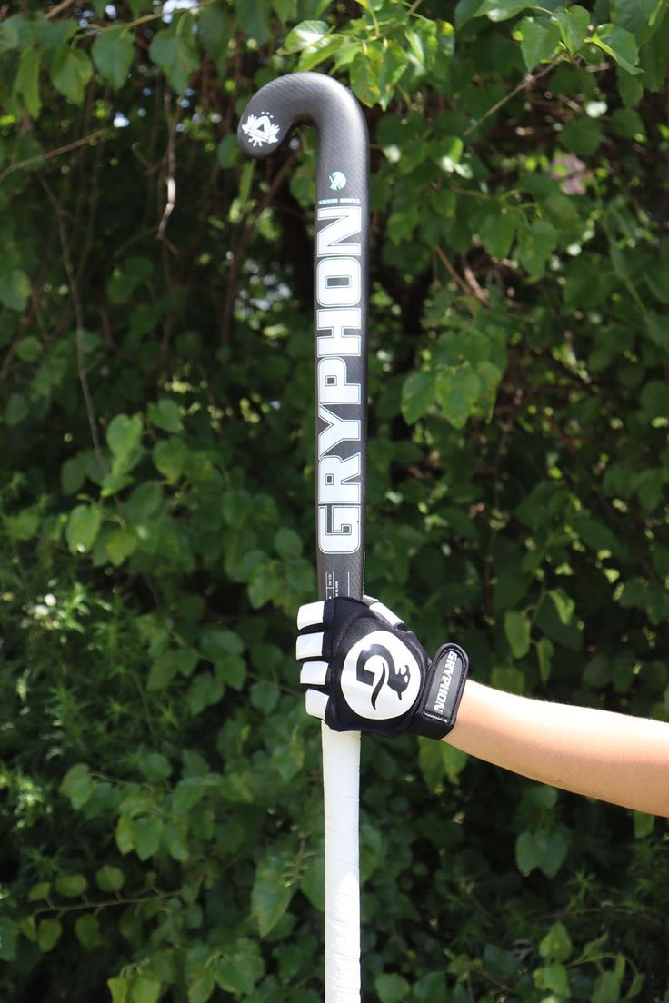 a close up of a person holding onto a pole with trees in the back ground