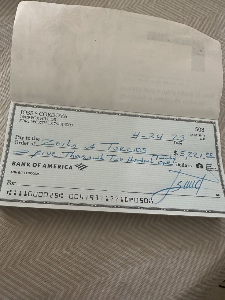 a check from bank of america is sitting on the floor next to a piece of paper