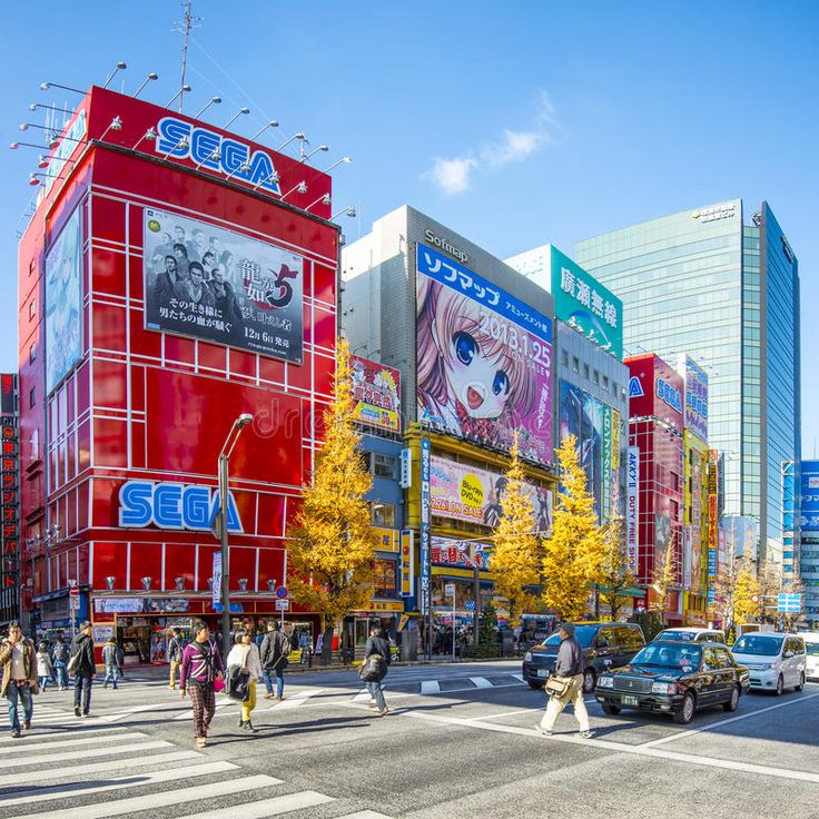 people are crossing the street in front of colorful buildings and tall skyscrapers on a sunny day