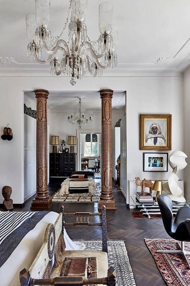 a living room filled with lots of furniture and a chandelier hanging from the ceiling