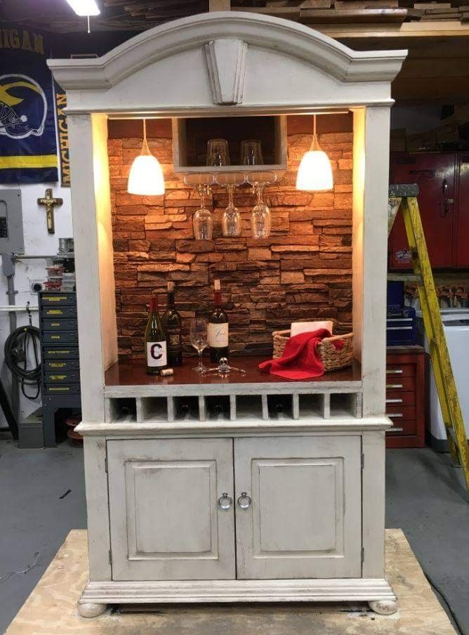 an entertainment center with wine glasses and bottles on it's display shelf in a shop