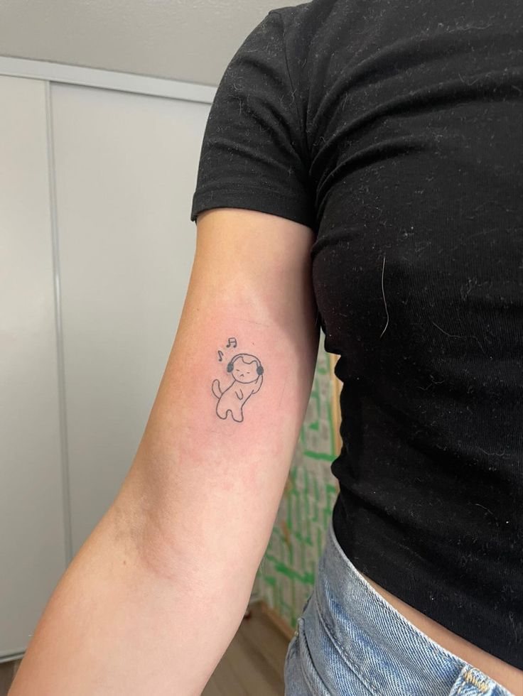 a woman's arm with a small tattoo of a dog on the back of her left arm