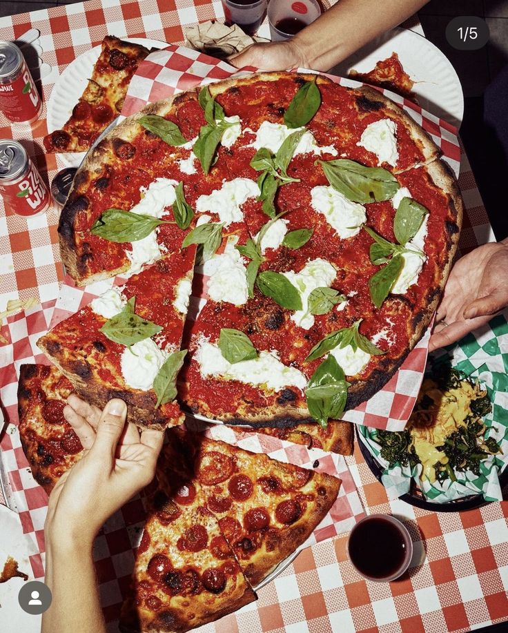 people are eating pizza at a table with red and white checkered tablescloths