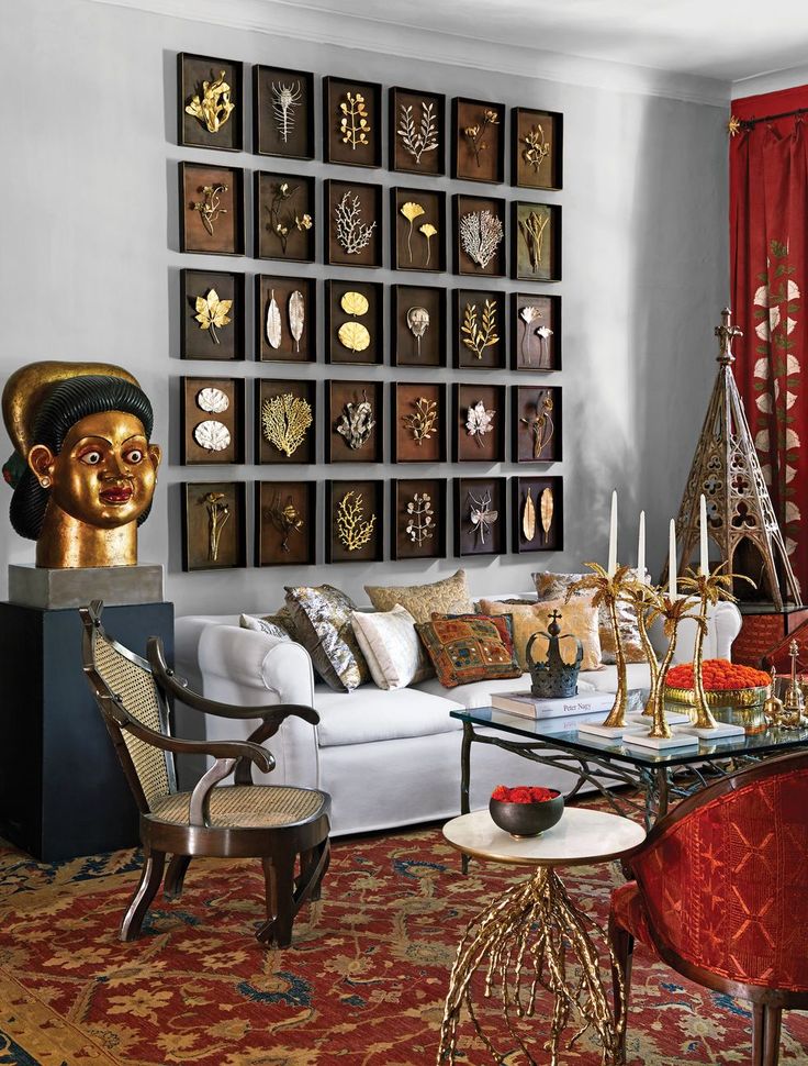 a living room filled with furniture and lots of gold decorations on the wall above it