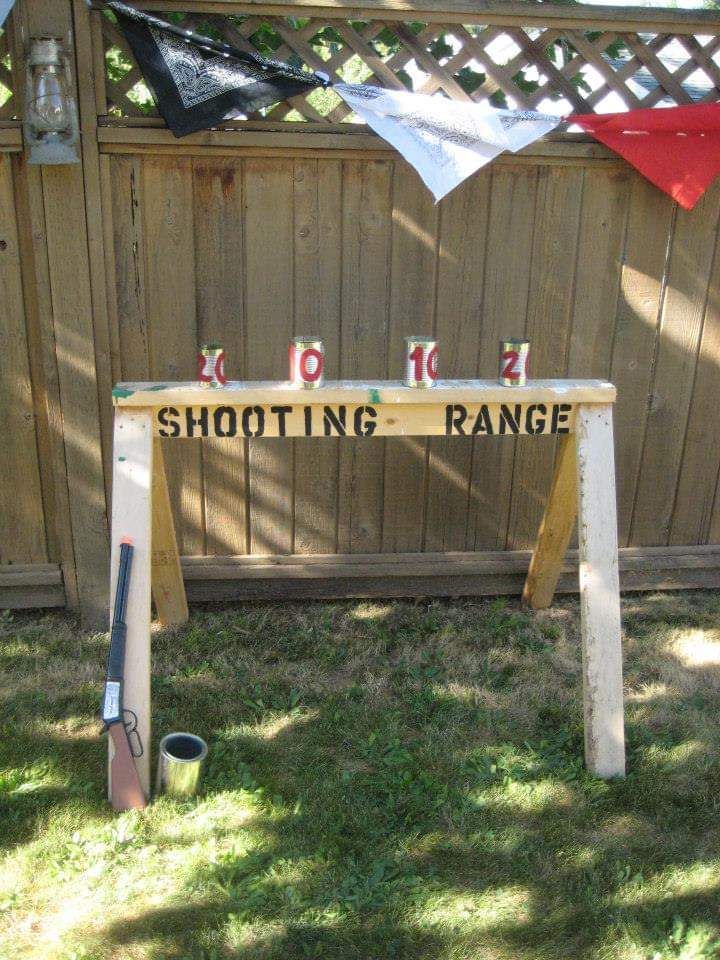 a wooden sign that says shooting range in front of a fence