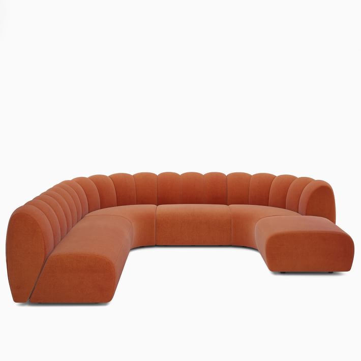 an orange sectional sofa sitting on top of a white floor