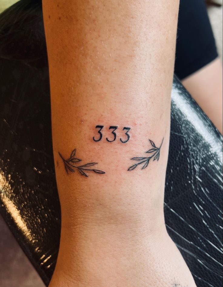 a woman's foot with an arrow tattoo on her left ankle that reads 35