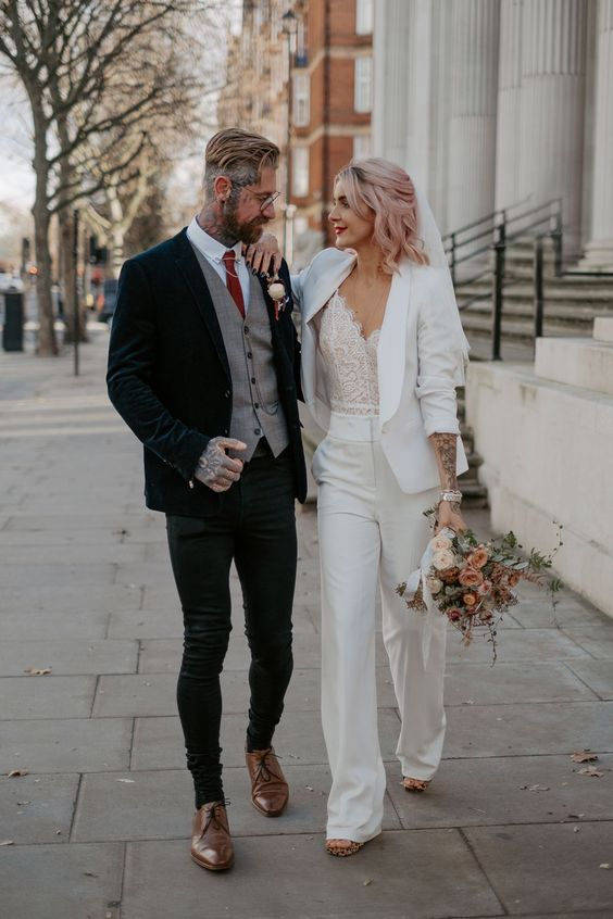 a bride and groom walking down the street