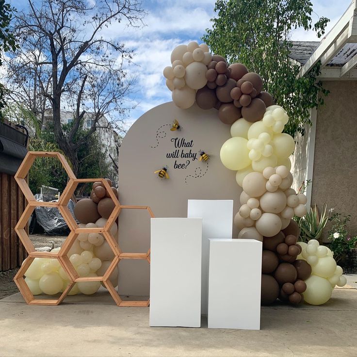 balloons and honeycombs on display in front of a sign