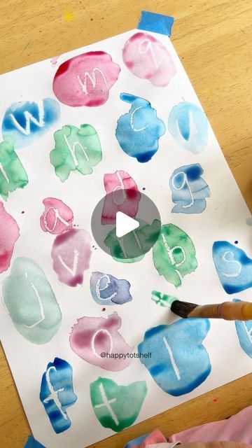 someone is painting letters with watercolors on paper