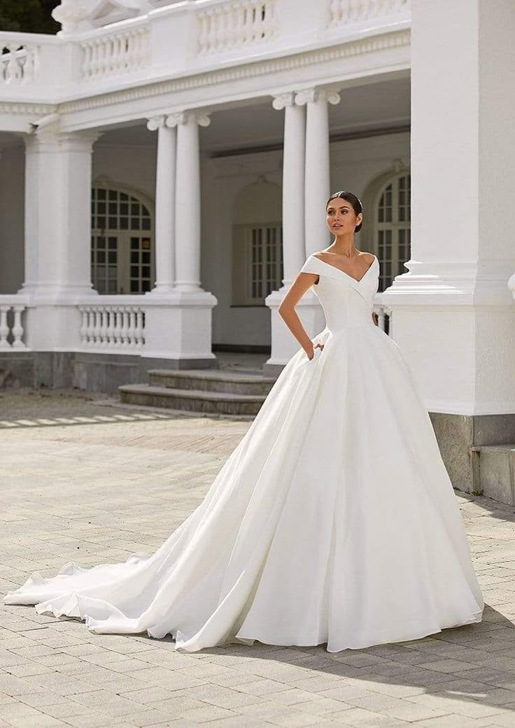 a woman in a white wedding dress posing for the camera