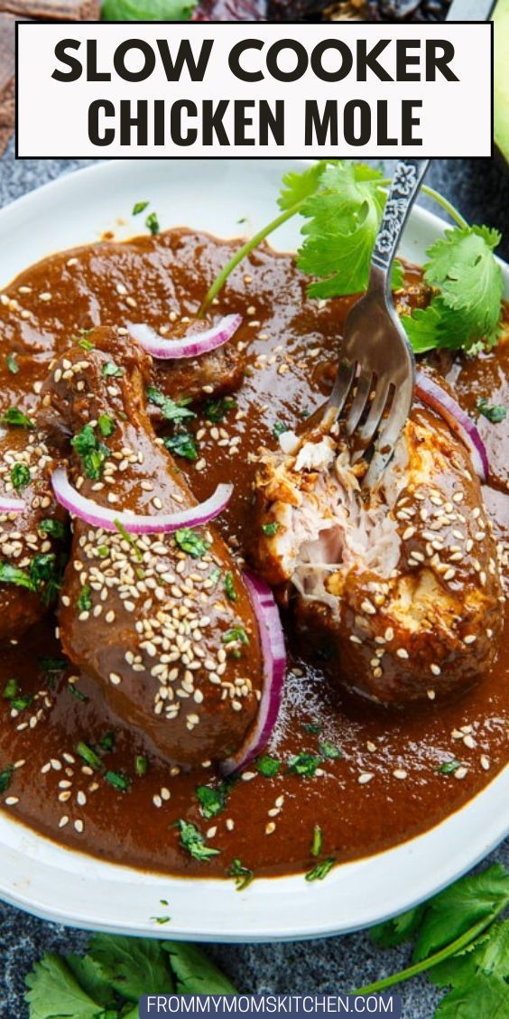 a white plate topped with meat covered in sauce and garnished with cilantro