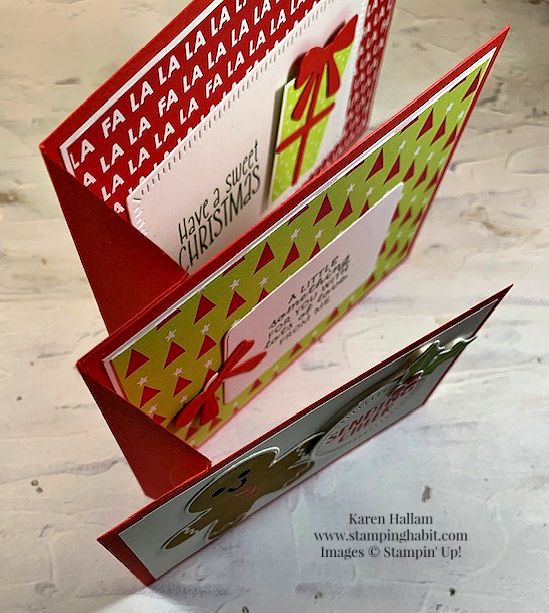 two folded christmas cards sitting on top of each other in an open book style holder