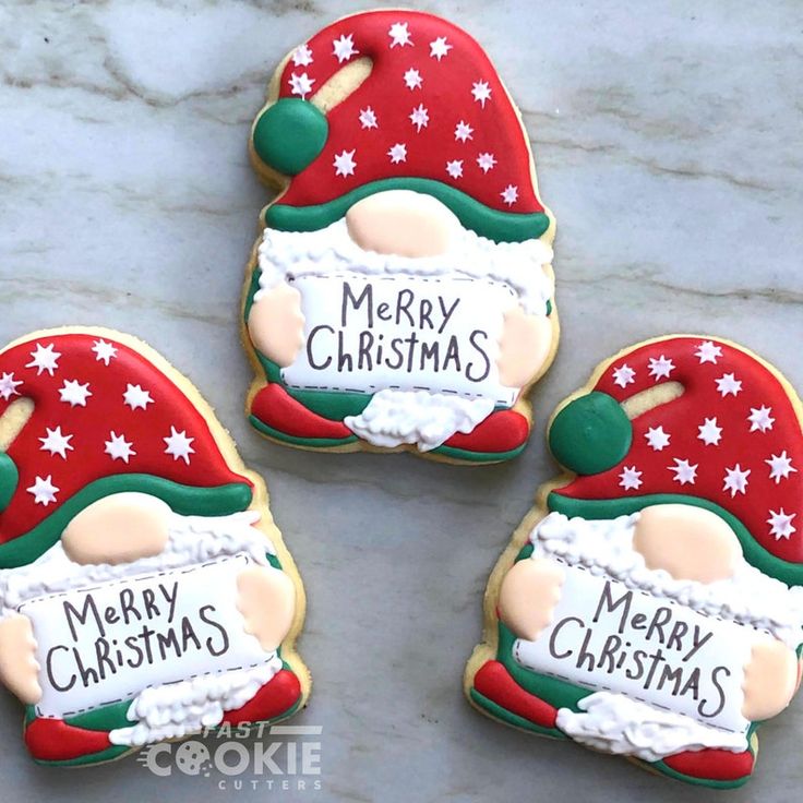 three decorated christmas cookies sitting on top of a table