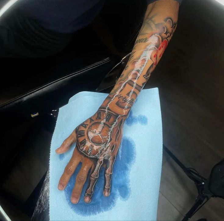 a person with a tattoo on their arm and hand